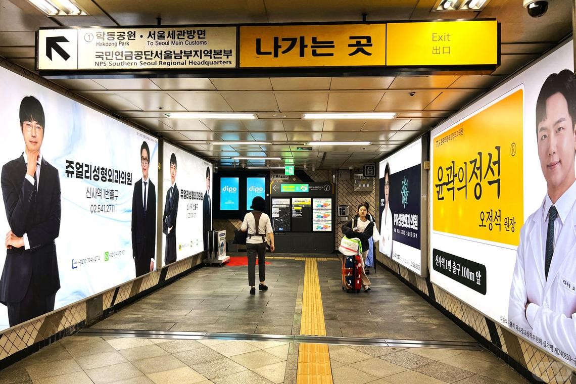 首尔江南区新沙地铁站一带，医美诊所林立。地铁站内的墙上都是医美诊所广告。.jpg
